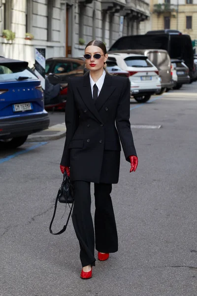 MİLAN, İTALYA - 28 Şubat 2025: Siyah takım elbiseli, kırmızı eldivenli ve ayakkabılı kadın Sportmax defilesinden önce, Milan Moda Haftası tarzı