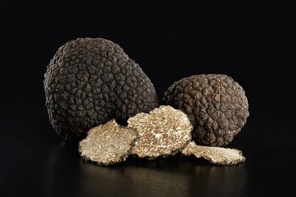 Black truffles and slices on black — Stock Photo, Image