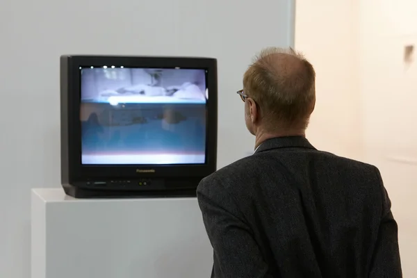 Artissima, contemporary art fair opening, man looking at video art — стокове фото