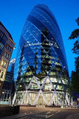 30 St Mary Axe glass building or Gherkin illuminated at night in London