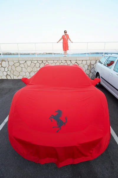 Tampa de pano vermelho Ferrari no porto com mulher — Fotografia de Stock