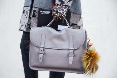 Man poses for photographers with Mulberry leather bag and Fendi accessory