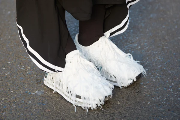 Женщина в меховых белых туфлях и брюках Adidas позирует для фотографов, уличный стиль — стоковое фото