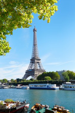 Eyfel Kulesi ve yeşil ağaç dalları Paris'te Seine Nehri manzaralı