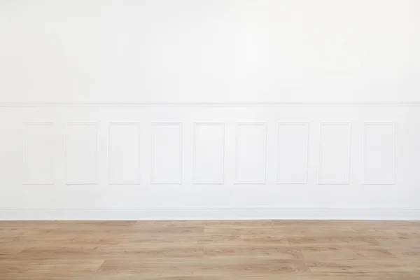 Empty white room with wooden floor and wood trimmed wall — Stock Photo, Image