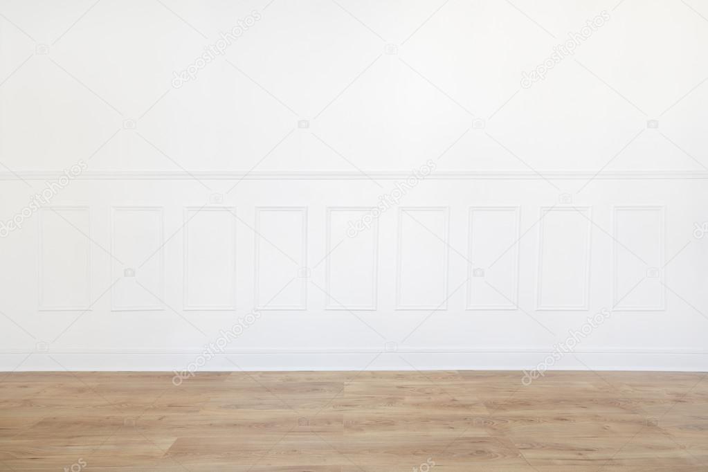 Empty white room with wooden floor and wood trimmed wall