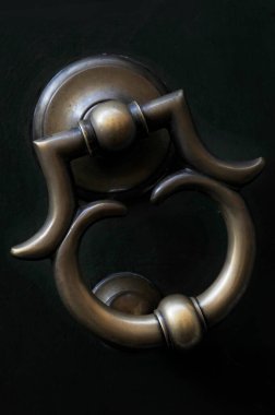 Antika süslemeli dökme demir kapı tokmağını çevreleyen yumuşak ışık. Eskici kapı tokmağı, dekoratif kapı mobilyaları, ana girişte ya da kapıda menteşeli bir demirbaş..