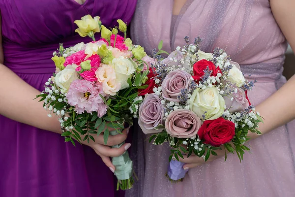 伴娘或亲密的女性客人 身穿淡紫色和淡紫色的漂亮的郁金香长袍 手持精致的混合花束 手牵着女性的手 为婚礼插花 — 图库照片