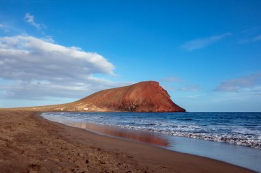 Sahilden Montana Roja 'nın manzarası Playa Tejita, Özel Doğal Rezerv ve Granadilla de Abona' da korunan volkanik alan, Tenerife, Kanarya Adaları, İspanya 'daki eşsiz bitki örtüsüne ve faunaya ev sahipliği yapıyor.
