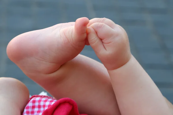 Newborn plays with hands and feet — Stock Photo, Image