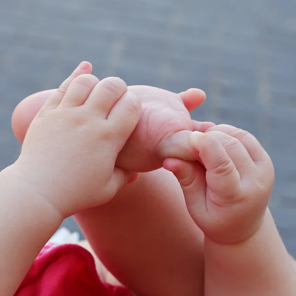 Newborn plays with hands and feet — Stock Photo, Image