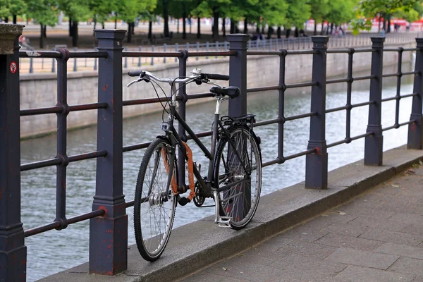 Велосипед, стоящий у перила на набережной на берегу реки Шпрее — стоковое фото