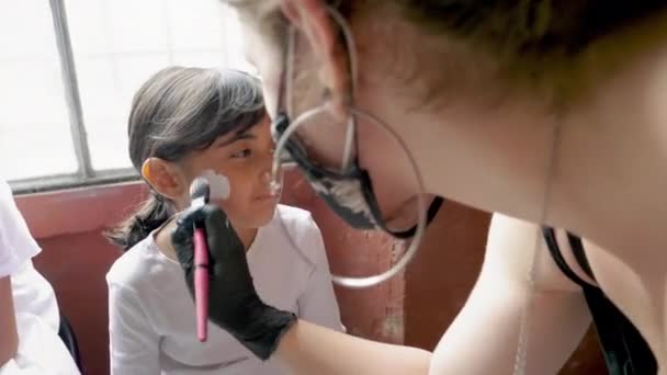 Жінка Малює Обличчя Дівчини Хеллоуїн — стокове відео