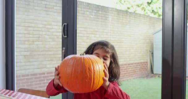 Portret Van Een Lachend Meisje Aan Tafel Met Pompoen — Stockvideo