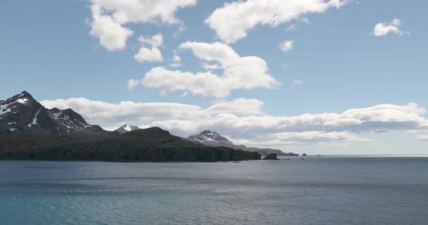 白い雲が空に向かって通過する岩の海岸と海 南ジョージア イギリス海外領土 — ストック動画