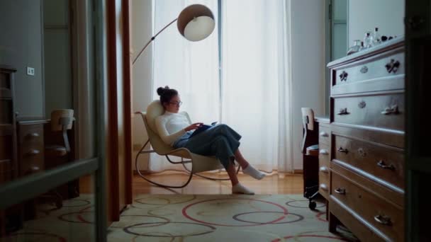 居間で本を読んでいる若い女性は — ストック動画