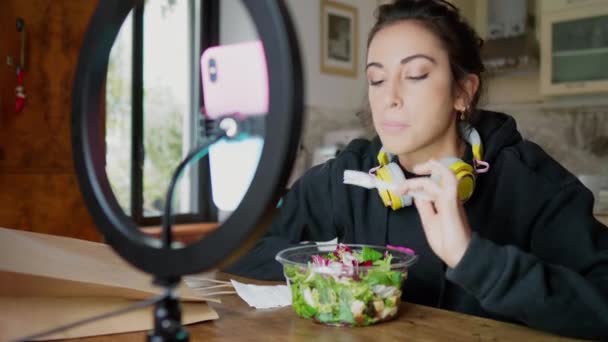 Young Woman Eating Salad While Having Video Call Kitchen — Stock Video