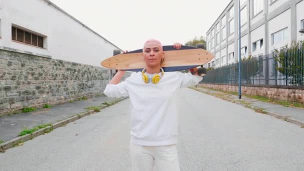 Ung Kvinna Med Skateboard Axlarna Står Mitt Gatan — Stockvideo