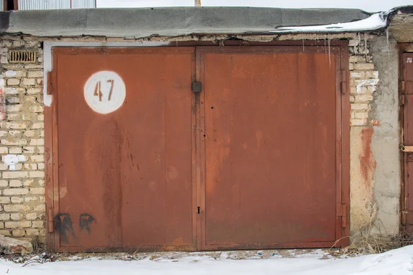 Porta de metal da garagem com fechadura. fundo de tijolo — Fotografia de Stock