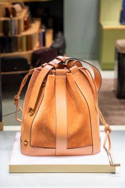 Şık süet ve deri omuz çantası şık bir perakende satış ortamında sergileniyor. Çantalar, moda tutkunları için mükemmel olan lüks ve entelektüelliği ön plana çıkarıyor.