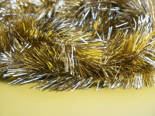 黄金と銀のチンセル 黄色の背景にクリスマスの装飾 — ストック写真