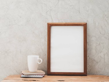 Tik ağacı ahşap çerçeve ve beyaz kahve fincanı çatı katı beton arka plan ile grunge masa üzerinde taklit