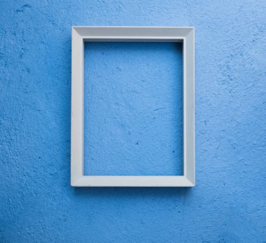 Klasik beyaz resim çerçevesi mavi çimento arkaplan üzerinde makara, düz yatıyordu