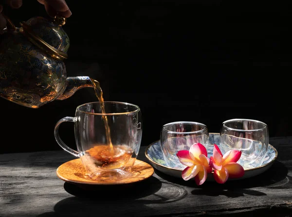 Налить Свежезаваренный Стакан Чая Цветком Plumeria Традиционный Чайник Стол Темного — стоковое фото