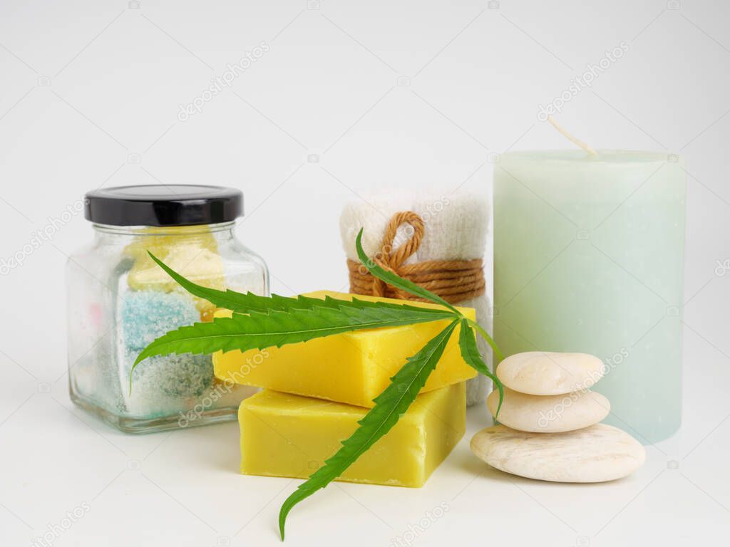 Spa hemp extract products with cannabis leaf soap bar and  white towel stone candle on white background