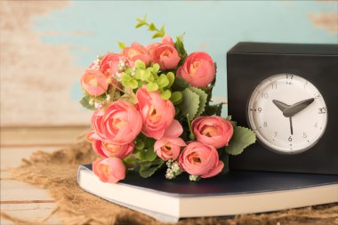 Çalar saat, not defteri ve ile yapay gül çiçek buketi 