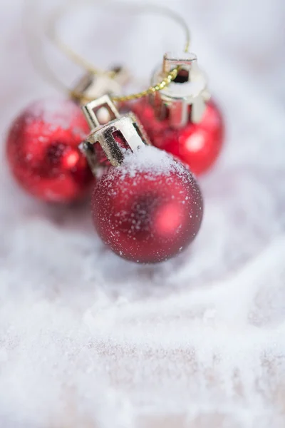 Glänzende rote Weihnachtskugeln über Schnee Hintergrund — Stockfoto