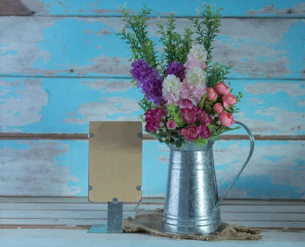 Un ramo de flores de rosas artificiales en lata de galvanizar y papel — Foto de Stock