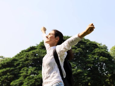 Mutluluk genç kadın gülümseme özgürlük ve rahatlama hafta sonu tatil bahçesinde.