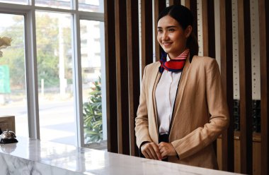 Güzel Asyalı resepsiyonist kadın tatil haftasonu için otelin önünde..