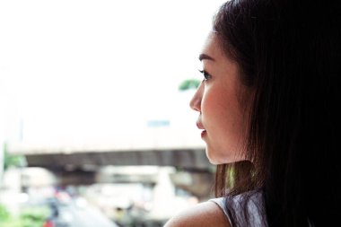 Yakın çekim güzel kadın mutlu gülümseme ve şehirde arıyor.