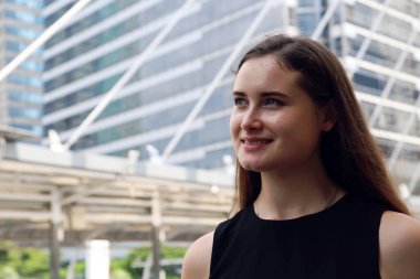 Güzel kadın gülümsüyor ve gökyüzüne bakıyor. Yazın şehirde seyahat ediyor..