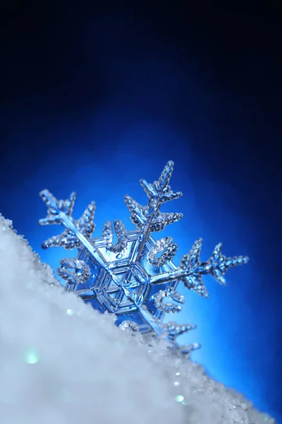 闪烁着白雪的雪花 蓝色的背景闪闪发光 — 图库照片