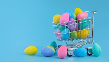 Colorful Easter eggs piled in shopping cart for Easter shopping.