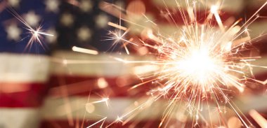 Vatansever 4 Temmuz kutlamaları için Amerikan bayrağının önünde kıvılcımlar uçuşuyor..