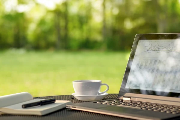 Laptop and coffee in outdoor office — Zdjęcie stockowe