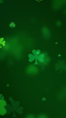 Aziz Patrick Günü arkaplanı yeşilde parıldayan yoncalarla dolu. Aziz Patrick gününü kutlamak için yeşil bir arkaplan arayan üç yapraklı yonca parçacıkları.