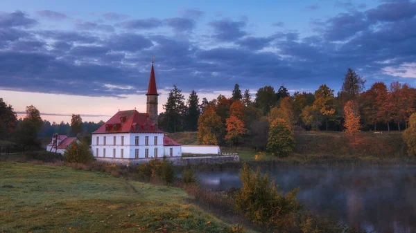 Gatchina şehrindeki Beyaz Prioratskiy Sarayı. Altın sonbahar boyunca sisli bir sabah..