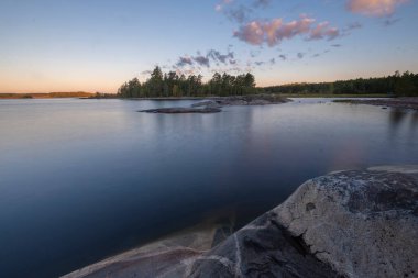 rocky shore of Lake Ladoga, Karelia, Russia with a view of the island on a summer morning.