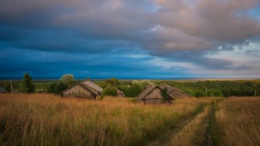 Rusya kırsalında, Vologda bölgesinde gün batımında geleneksel ahşap kesim köy evleri