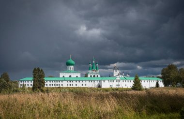 Rusya 'nın Leningrad bölgesinde Roshinskoye Gölü' ndeki Kutsal Üçlü Alexander Svirsky Manastırı. Fırtınalı bir gökyüzünün arka planında, bir yaz gününde