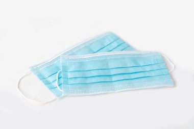 Beyaz yüzeyde mavi tıbbi tek kullanımlık maskeler