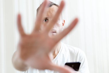 Adam kameraya avuç içi gösteriyor, sembolü durdur.