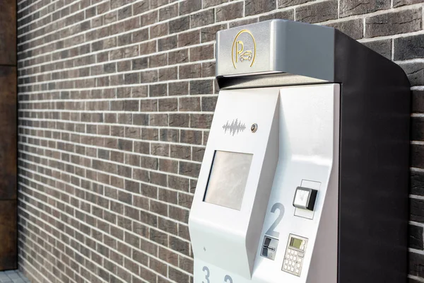 payment machine for parking near a brick wall