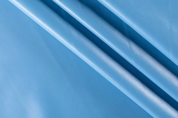 青い空の色で服を縫製するための人工皮革の折り目を持つ表面背景 — ストック写真