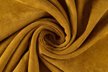 Perde kumaşı hardal renkli tuval, spiral şeklinde sarılmış.